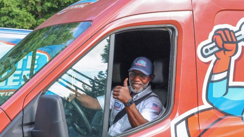 Climate Heroes technician in a van, smiling with a thumbs up