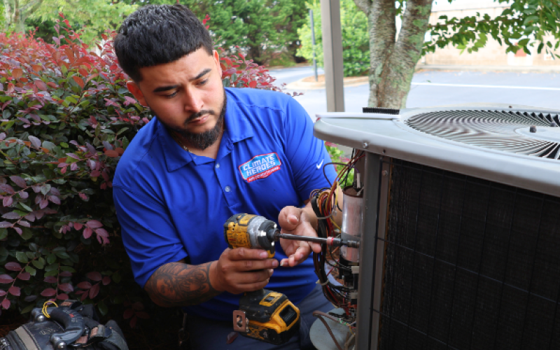 Climate Heroes service technician servicing an outdoor unit